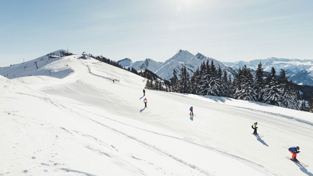 Skieurs skiant en descente dans le domaine skiable